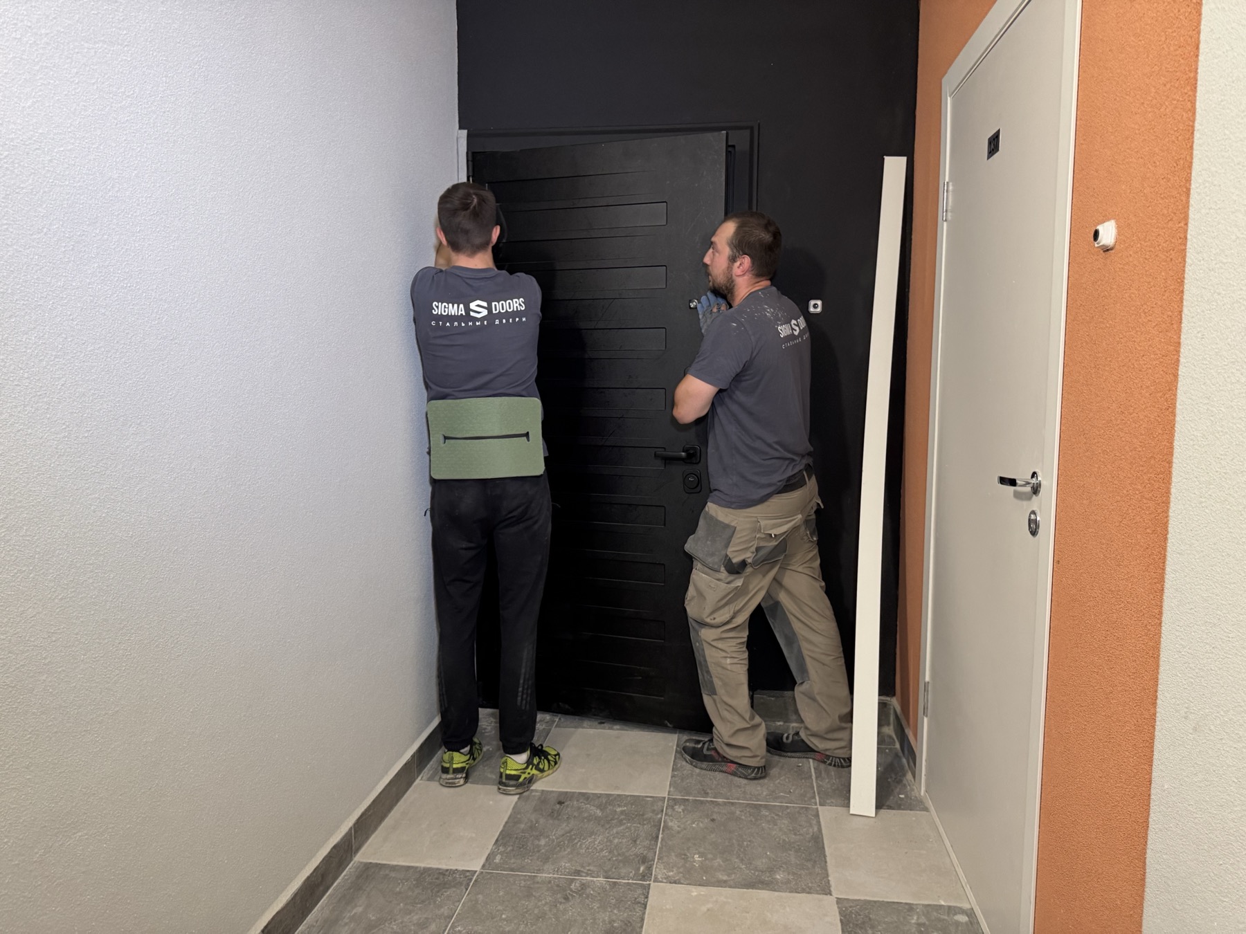Монтажники Sigma Doors устанавливают входную дверь